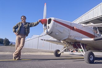 Smiling Man Standing Next to a Monoplane