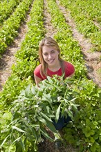 young woman with green plants in field