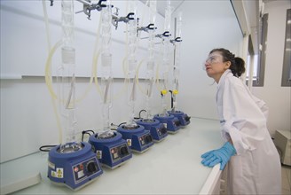 Female lab technician wearing safety glasses checking test array