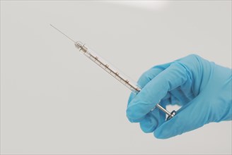 Lab technician holding syringe close-up of hand