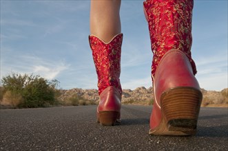 Woman in red boots walking to horizon