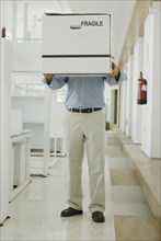 Man carrying box in office