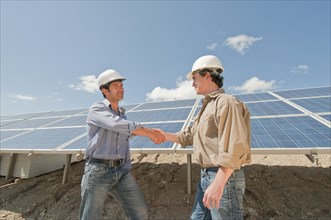 engineers shaking hands in solar plant