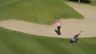 Caucasian woman in sand trap on golf course
