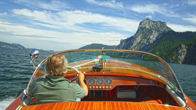 Caucasian man driving speedboat on remote lake