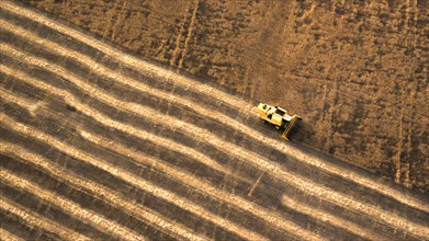 Aerial view of combine harvester in farm field