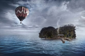 Hot air balloon floating over house on tropical island