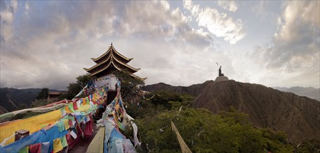 Panoramic view of prayer flags and traditional building on mountain