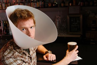 Man wearing medical cone in bar