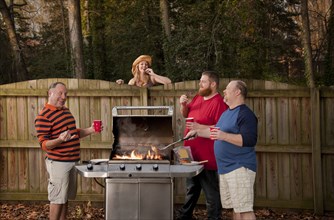 Woman watching neighbors barbecuing food