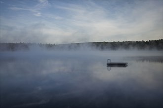 Dock floating on misty remote lake