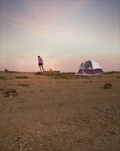 Woman camping in remote desert field