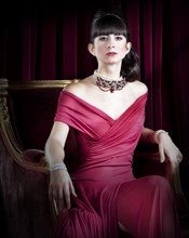 Caucasian woman wearing jewelry and red evening gown