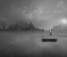 Caucasian ballet dancer on floating dock in foggy lake