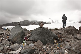 Pensive man standing on rocks in winter landscape