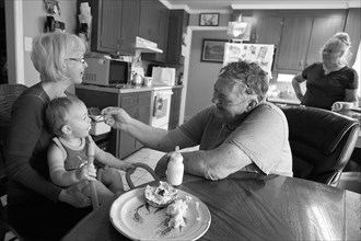 Caucasian grandfather feeding grandson in kitchen