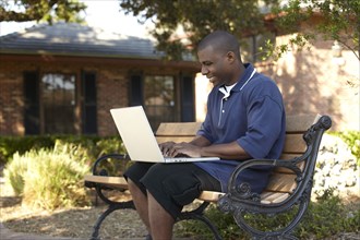 Black man typing on laptop