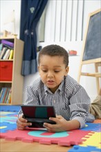 Mixed race boy playing video game