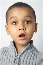 Mixed race boy with surprised expression