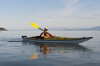 Hispanic woman kayaking on lake