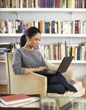 Woman sitting in chair using laptop