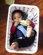 African American baby laying in laundry basket