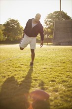 Man stretching on football field