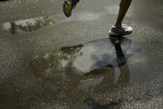 Woman running through puddle