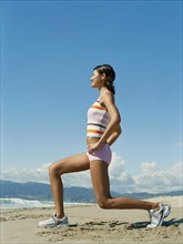 Mixed race woman exercising on beach