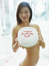 Naked woman holding birthday cake