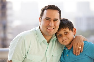 Hispanic father hugging son and smiling