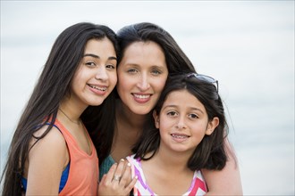 Hispanic mother and daughters smiling outdoors