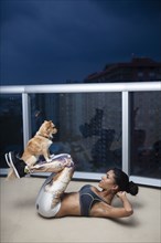 Dog balancing on legs of mixed race athlete during exercise