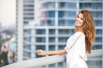 Hispanic woman standing on urban balcony