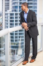 African American businessman standing on urban balcony