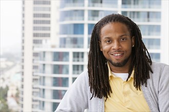 African American man smiling on urban balcony