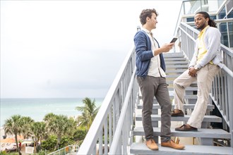 Businessmen talking on steps over urban beach