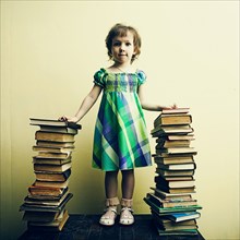 Caucasian girl standing with stacks of book