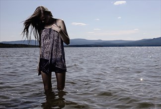 Woman wading in remote lake