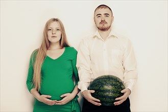 Man holding watermelon with pregnant girlfriend