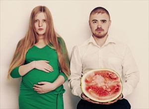 Man holding watermelon with pregnant girlfriend