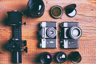 Cameras and lenses on wooden table