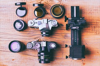 Cameras and lenses on wooden table