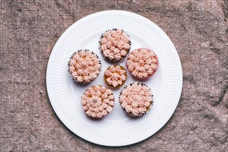 Close up of cupcakes with pink frosting on plate