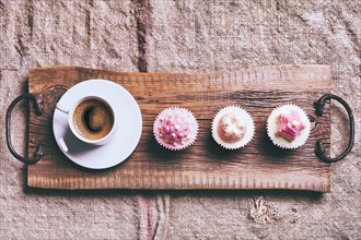 Coffee and cupcakes on wooden tray