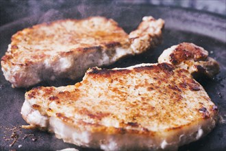Pork chops searing in pan
