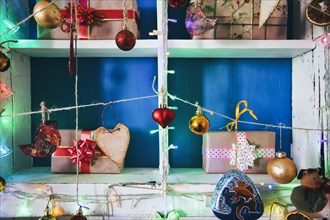 Gift boxes on wooden shelves near ornaments