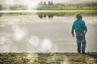 Boy watching ripples in lake