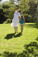 Mother and daughter walking together in grass