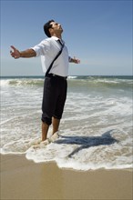 Businessman wading in ocean